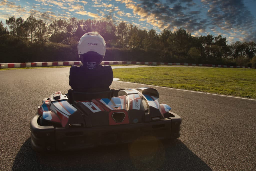 Pilote de karting sur circuit en plein air.