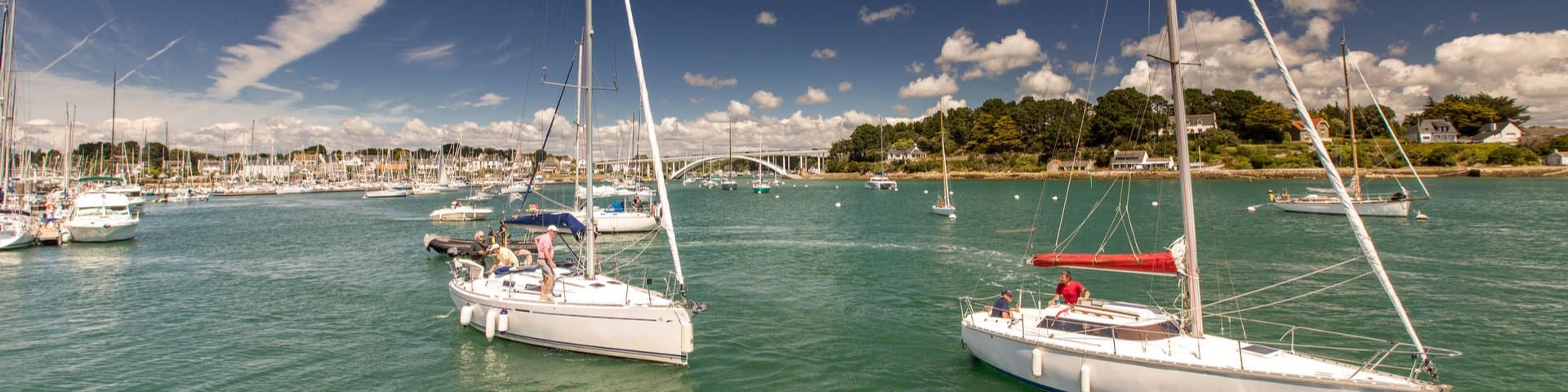 Voiliers sur l'eau près d'un pont en Bretagne.